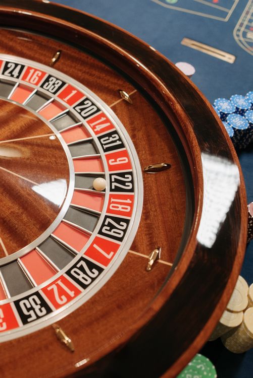 Bàn roulette nhìn từ trên xuống với chip casino xếp trên lưới đặt cược